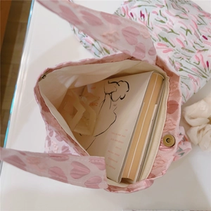 Detail of pink heart-patterned tote bag with magnetic clasp and fabric lining