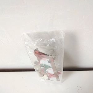 Close-up of a wooden Santa Claus door frame decoration packaged in a clear plastic bag