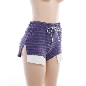 Détail du short violet texturé avec fente latérale et doublure de poche blanche contrastée
