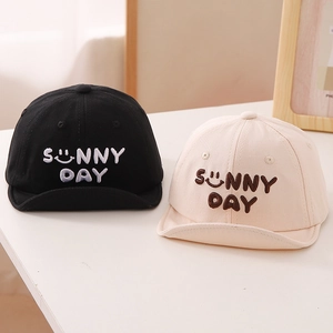 Detail of baby soft-brim hats in beige and black with Sunny Day embroidery and smiley face