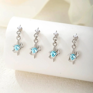 Titanium steel planet earrings with blue heart zircon and small pearls displayed on stand