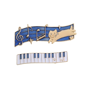Set of two musical cat hair clips featuring blue enamel sheet music and white piano keys