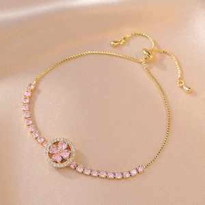 Elegant adjustable gold bracelet featuring pink heart zircon clover and silk backdrop