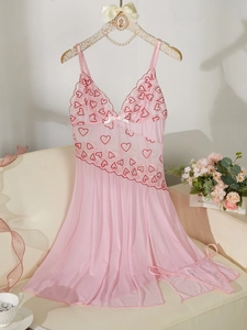 Détail de nuisette rose en dentelle avec broderie de coeurs rouges et tissu en maille
