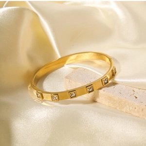 Detail eines 18k vergoldeten Titan-Armbands mit quadratischen Zirkonia und gebürsteter Optik