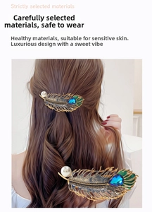 Detail of vintage gold leaf hair clip with green enamel and blue teardrop gemstone