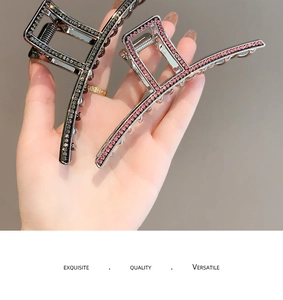 Close-up of large luxury rhinestone hair claws in pink silver and grey gunmetal finish