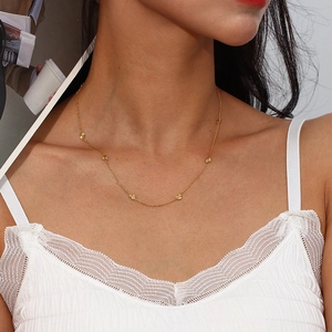 Model wearing gold stainless steel necklace with multiple small heart charms for women