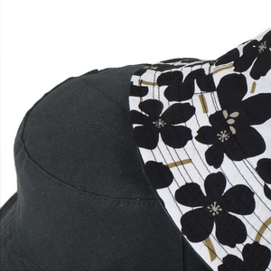 Detail shot of black cotton bucket hat featuring floral pattern brim and stitching quality