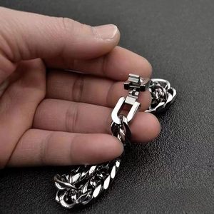 Dettaglio di un bracciale a maglia cubana argento con chiusura a moschettone quadrata
