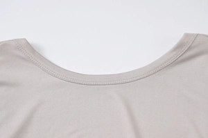 Dettaglio del girocollo e della trama in maglia fine su questo top grigio da donna aderente