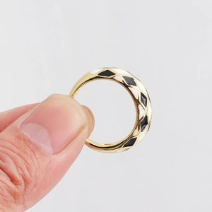 Detail of gold-plated checkerboard enamel ring showing black and white diamond pattern