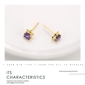 Macro detail of gold plated turtle stud earring featuring faceted purple zircon