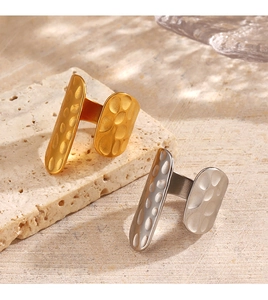 Detailed view of 18K gold and silver plated hammer-textured rings on stone surface