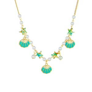 Golden ocean theme necklace with shell starfish charms and white pearls on white background
