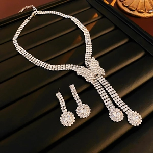 Close-up of silver bow necklace and matching earrings set with sparkling crystals