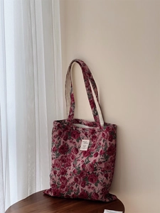 Gros plan sur le tissu jacquard rose bordeaux vintage et l'étiquette du sac fourre-tout