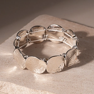 Dettaglio della trama in metallo martellato e dei doppi cordini elastici su questo bracciale