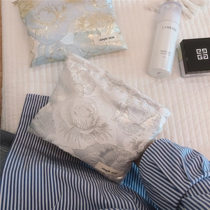 Detail of elegant silver rose jacquard fabric cosmetic bag with a simple wish label