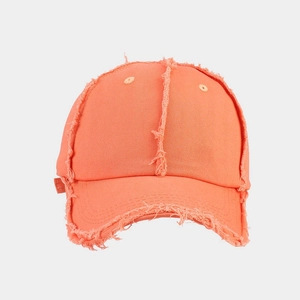 Close-up of bright orange baseball cap featuring distressed edges and frayed fabric detail