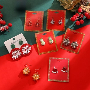 Detailed macro view of a festive Christmas earring set with snowman and snowflake designs