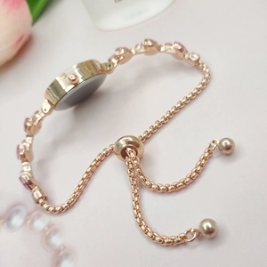Détail du bracelet de montre en or rose avec fermoir coulissant et pierres roses