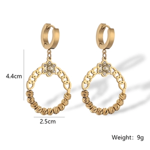 Détail de boucles d'oreilles dorées de 4,4 cm avec fleur en diamant et bille métal