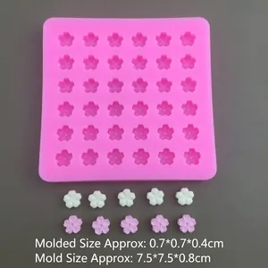 Pink silicone mold with 36 cherry blossom cavities and small floral resin samples