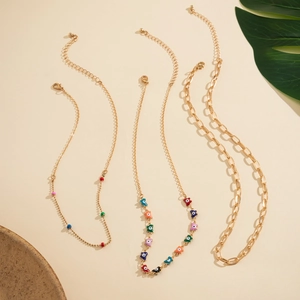 Detail of gold lobster clasp and adjustable extension chain on colorful charm necklaces