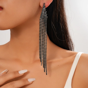 Close-up of long black rhinestone tassel earrings worn by a model for a luxury look