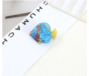 Detailed shot of tropical fish hair clip in blue acetate with striped fins and rhinestone
