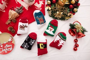 Flat lay of six thick Christmas coral fleece socks with reindeer and Santa Claus patterns