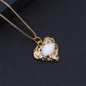 Detail of heart pendant necklace with white oval crystal on black leather background