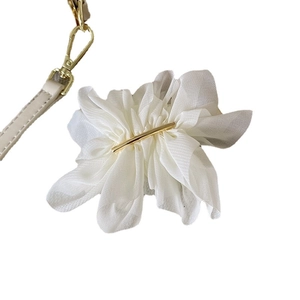 Barrette fleur en mousseline blanche avec accents en métal doré sur fond blanc pur
