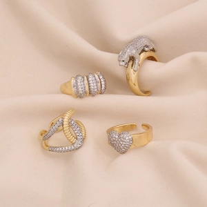 Golden geometric heart rings and panther design with zircon inlays on cream fabric