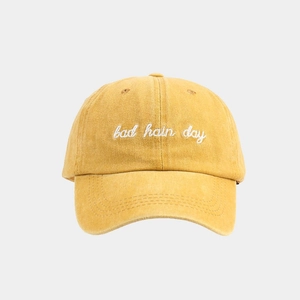 Detailed embroidery of 'bad hair day' text on washed cotton mustard yellow baseball cap