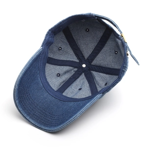 Inside view of navy washed denim baseball cap showing premium stitching and metal buckle