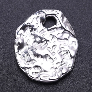 Macro view of silver stainless steel oval pendant with hammered texture and top hole