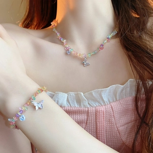 Détail du collier de perles d'eau douce colorées avec pendentif papillon sur modèle
