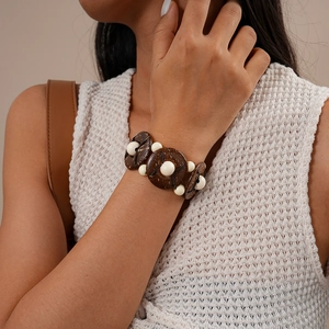 Detailed close-up of ethnic beaded bracelet with dark wood coconut shells and white beads