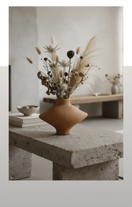 Détail d'un vase géométrique en terre cuite avec texture brossée et fleurs séchées