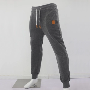 Detailed close-up of dark grey men's joggers with elasticated cuffs and drawstring waist