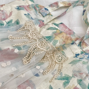 Detailed macro of vintage tulip print linen tote with white mesh and crochet floral lace