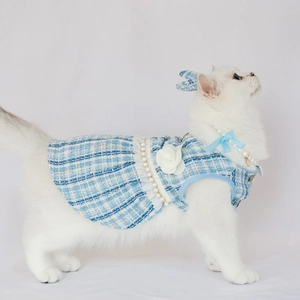 Close-up of blue tweed pet dress with pearl trim and white camellia flower detail