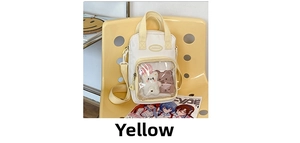 Detail of cute yellow canvas bag featuring transparent PVC pocket with plush bear charms