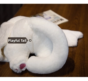 Detailed close-up of fluffy white plush toy tail with pink embroidered paw pad accents
