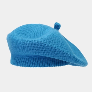 Detailed view of blue knitted beret showing fine texture and classic top stem detail