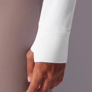Detail of white sports jacket sleeve featuring functional thumbholes for wind protection