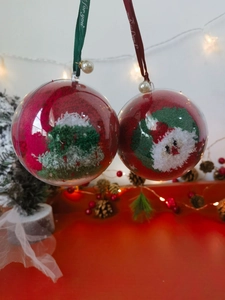 Macro shot of hanging clear Christmas balls with Santa Claus and tree knitting inside