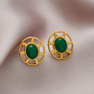 Boucles d'oreilles ovales dorées vintage avec pierres vertes sur fond de soie